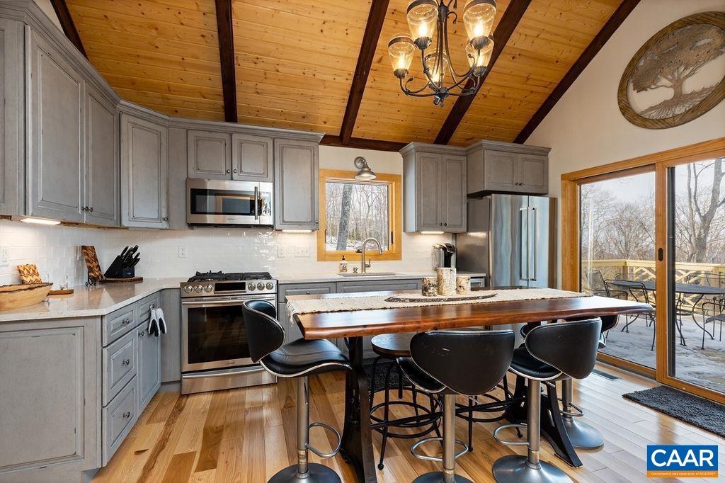 134 Squirrel Tree Lane Roseland, VA 22967 - Photo 6 of 40 a kitchen with stainless steel appliances granite countertop a stove top oven a sink dishwasher a dining table and chairs with wooden floor