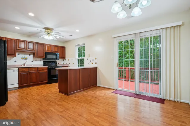 a kitchen with kitchen island granite countertop a sink cabinets and stainless steel appliances