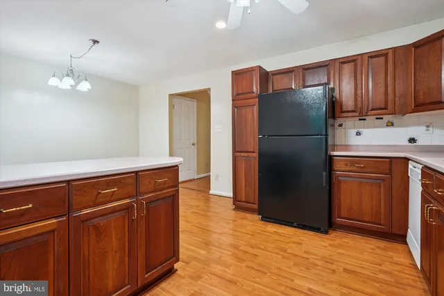 a kitchen with stainless steel appliances granite countertop a refrigerator a oven and a sink with cabinets