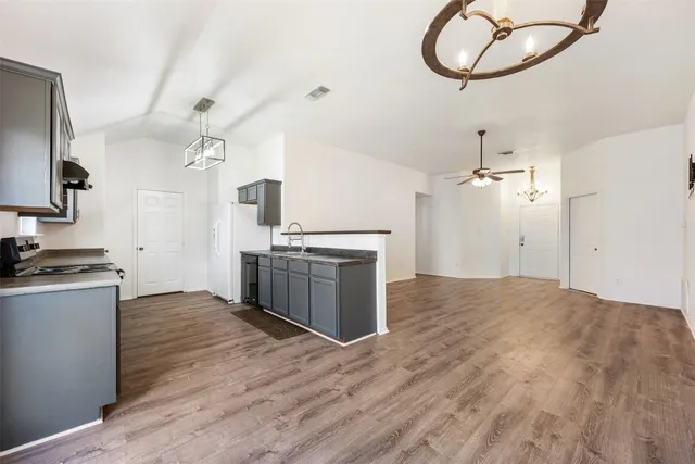 a kitchen with granite countertop a stove a sink and a chandelier