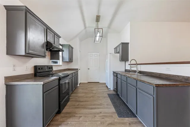a kitchen with stainless steel appliances granite countertop a sink and stove