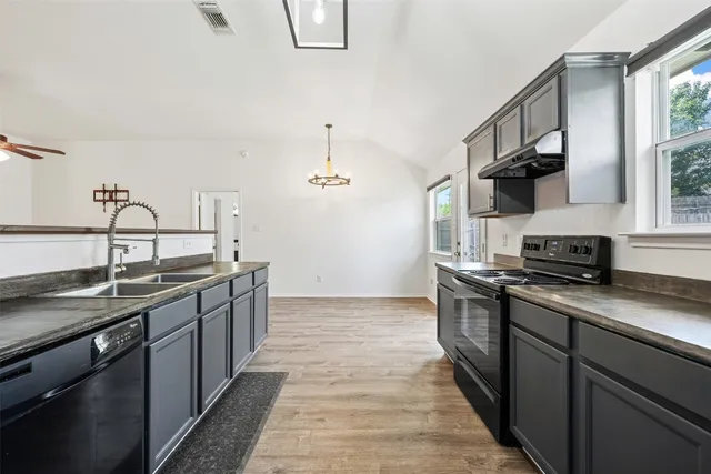 a kitchen with stainless steel appliances granite countertop a sink stove and cabinets