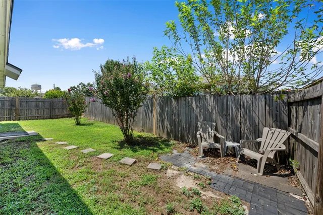 a view of backyard with a table and chairs and a large tree