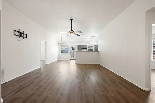 a view of a room with wooden floor and kitchen view