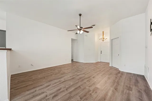 a view of a chandelier fan and hardwood floor
