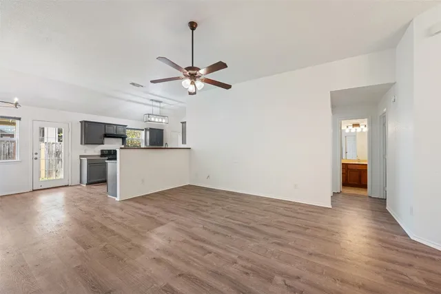 a view of a big room with wooden floor and a kitchen