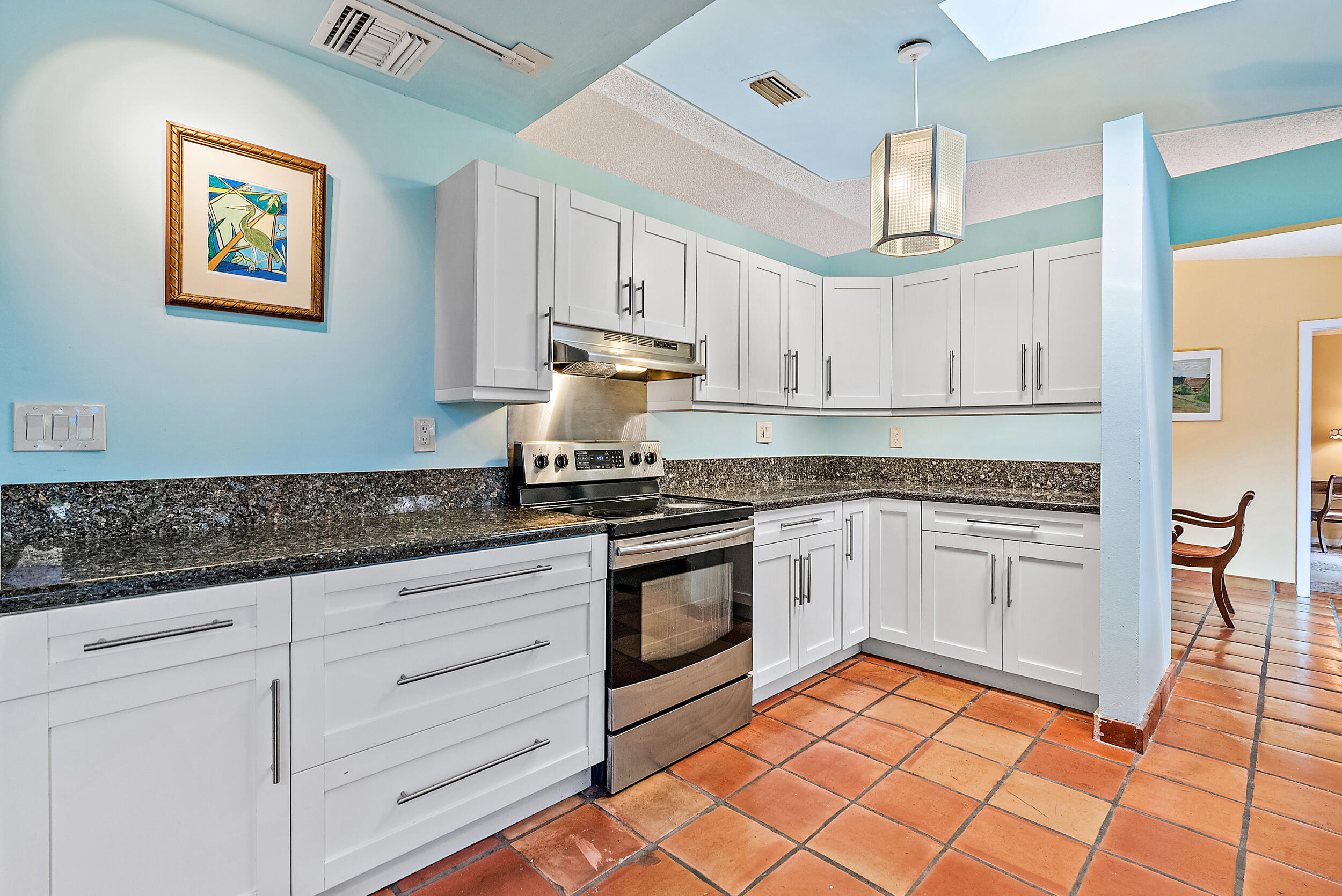 154 Chapel Lane Tequesta, FL 33469 - Photo 12 of 28 a kitchen with granite countertop white cabinets stainless steel appliances and sink