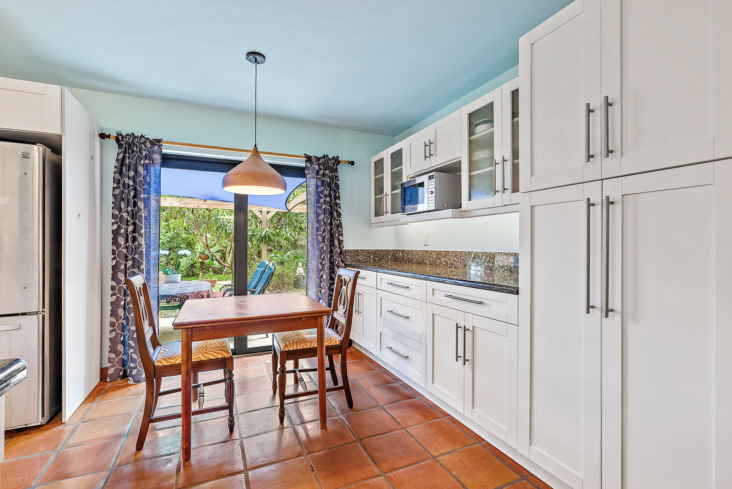 154 Chapel Lane Tequesta, FL 33469 - Photo 13 of 28 a kitchen with stainless steel appliances granite countertop a stove a refrigerator white cabinets and a dining table