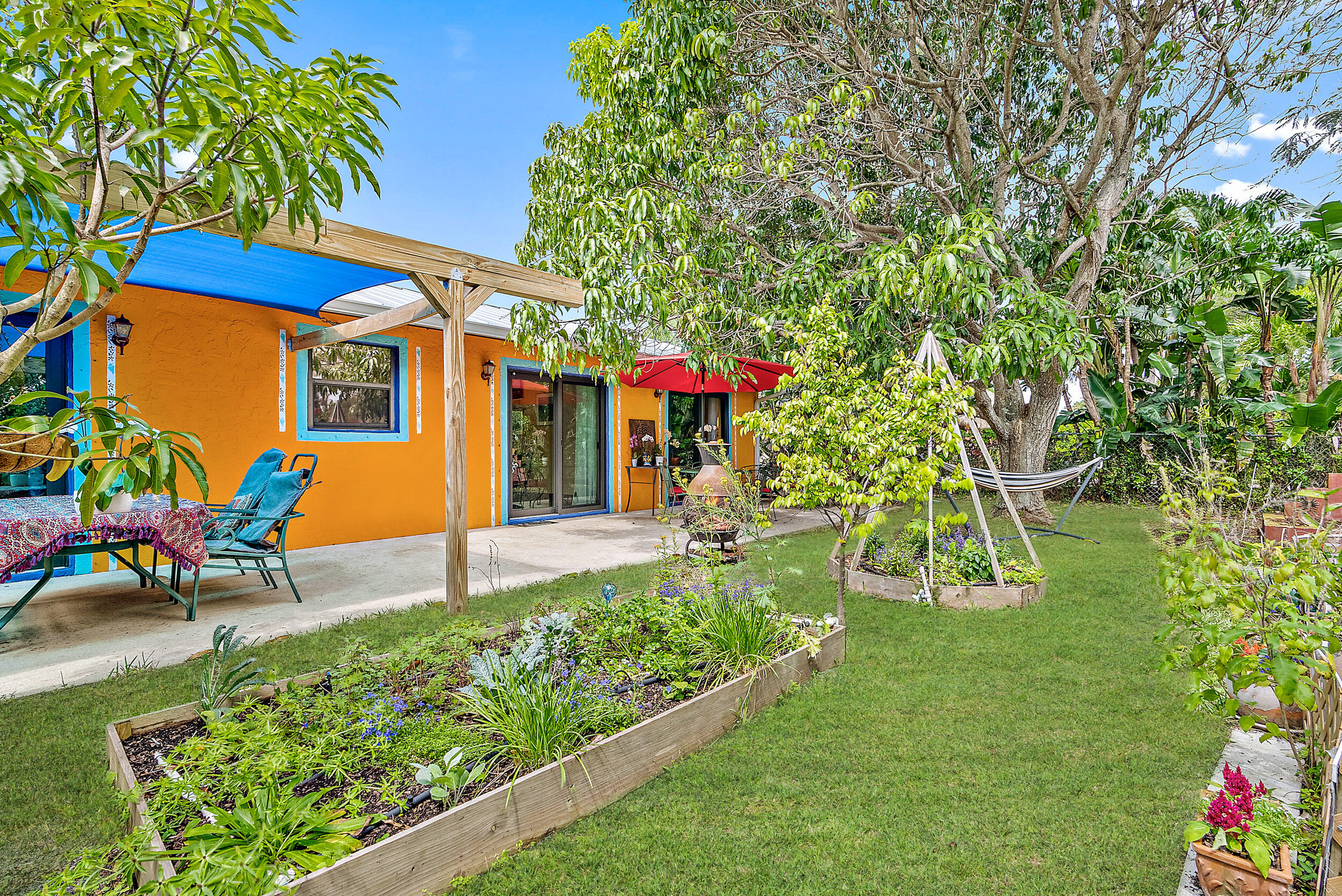 154 Chapel Lane Tequesta, FL 33469 - Photo 25 of 28 a view of a house with a backyard and a patio