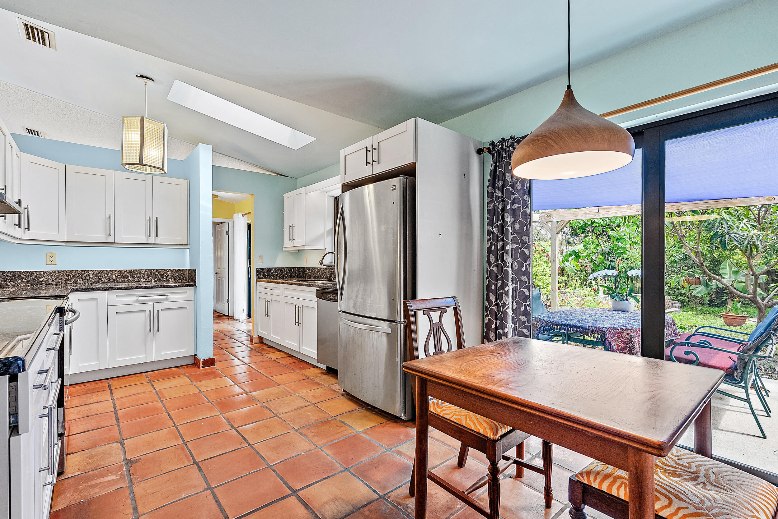 154 Chapel Lane Tequesta, FL 33469 - Photo 9 of 28 a kitchen with stainless steel appliances granite countertop a stove a refrigerator a oven a sink with a dining table and chairs