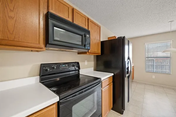 a kitchen with a refrigerator sink and wooden cabinets