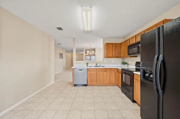 a large kitchen with a refrigerator and a stove top oven
