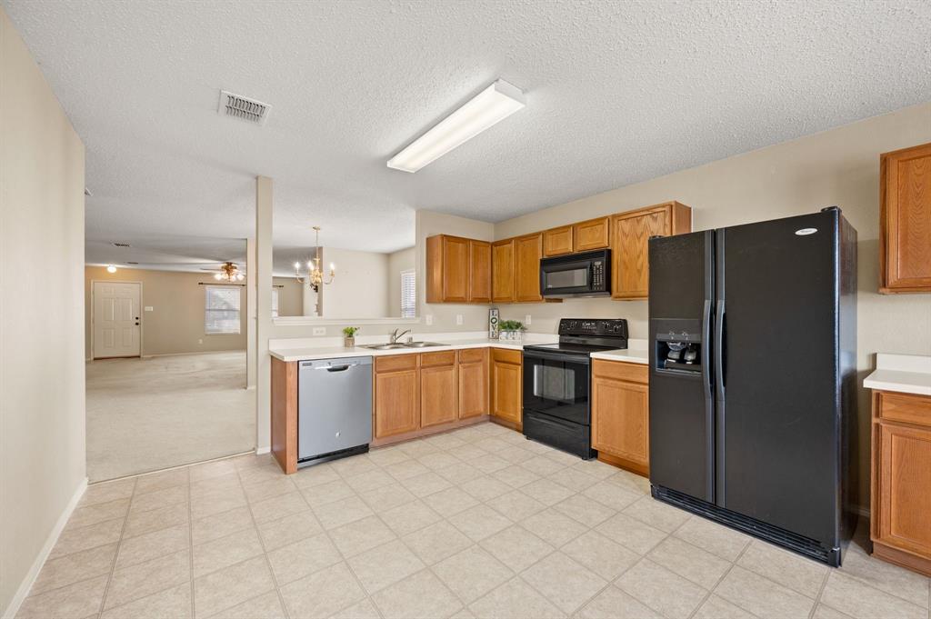 5308 Temecula Road Fort Worth, TX 76244 - Photo 19 of 37 a large kitchen with a refrigerator and a stove top oven