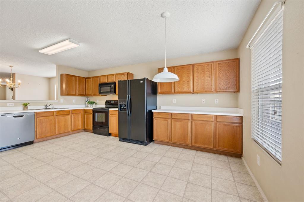 5308 Temecula Road Fort Worth, TX 76244 - Photo 21 of 37 a kitchen with granite countertop a sink stainless steel appliances and cabinets