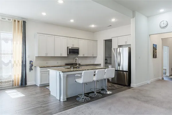 a kitchen with stainless steel appliances granite countertop a stove a refrigerator and a refrigerator