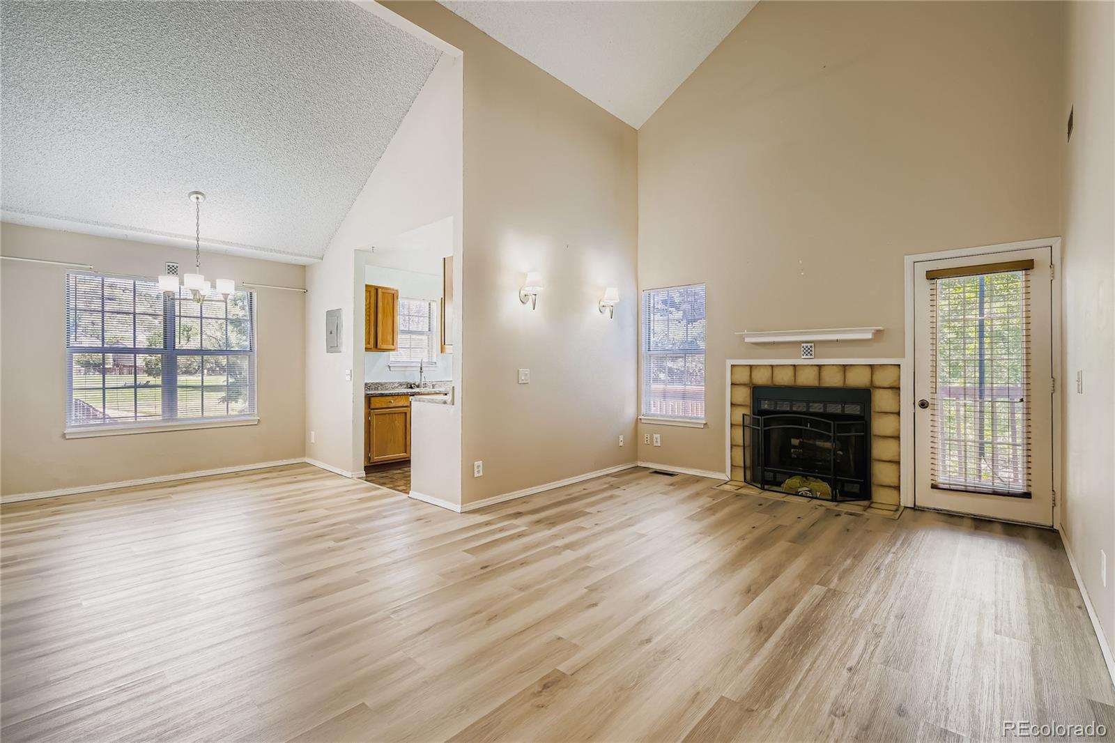 2129 Troy Court Colorado Springs, CO 80918 - Photo 11 of 27 an empty room with windows a fireplace and wooden floor