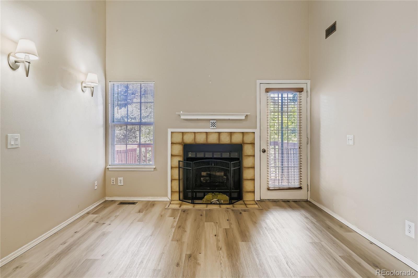 2129 Troy Court Colorado Springs, CO 80918 - Photo 12 of 27 an empty room with fireplace wooden floor and windows