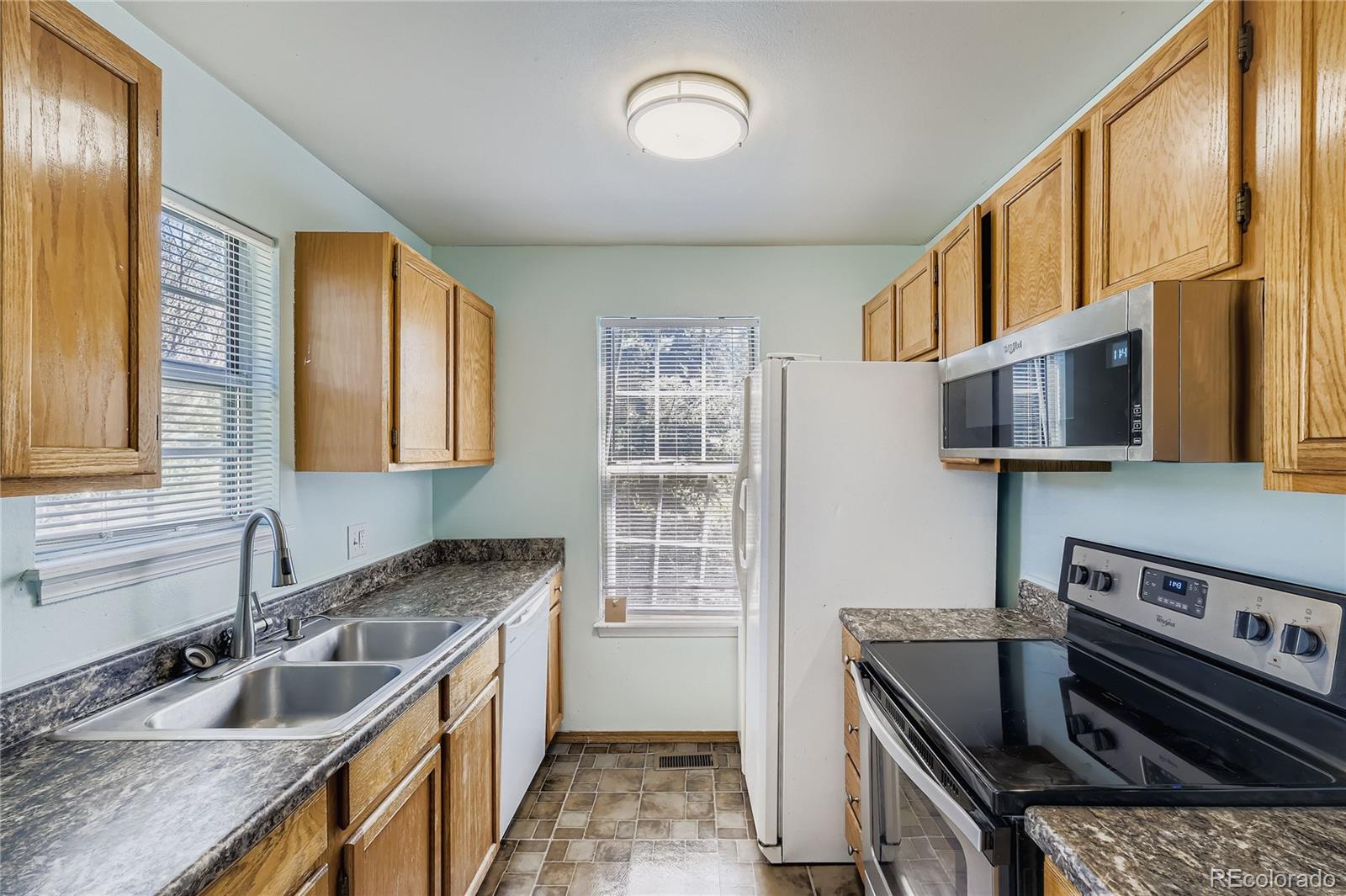 2129 Troy Court Colorado Springs, CO 80918 - Photo 7 of 27 a kitchen that has a sink a stove and a wooden cabinets