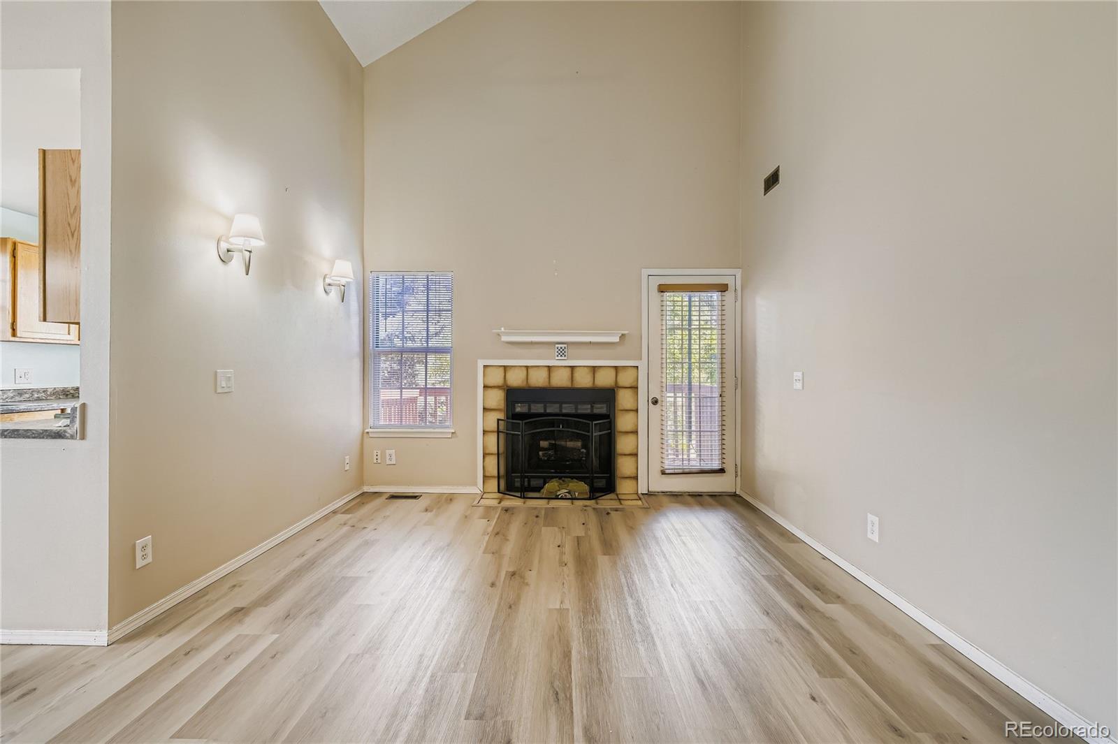 2129 Troy Court Colorado Springs, CO 80918 - Photo 8 of 27 a view of empty room with a fireplace and wooden floor