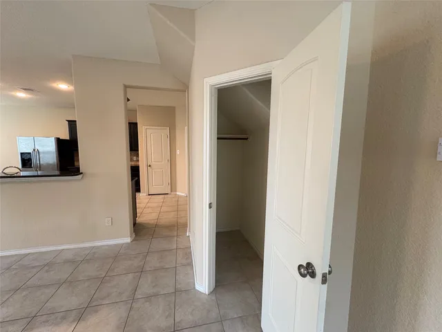 a view of a hallway with wooden shelves