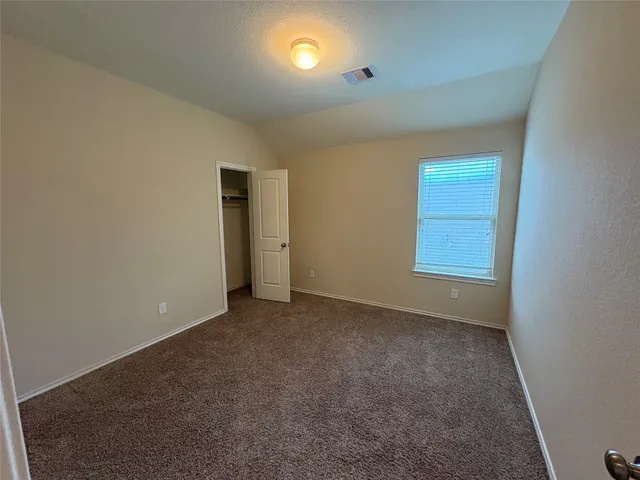 an empty room with windows and closet