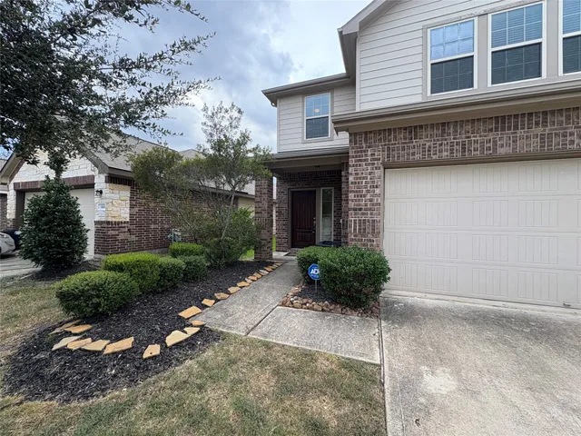 a view of a house with a yard and potted plants