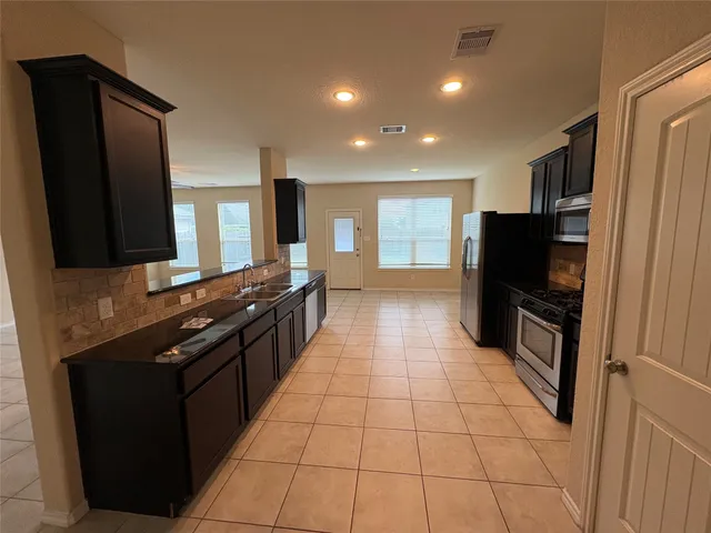 a kitchen with stainless steel appliances a refrigerator and a stove top oven