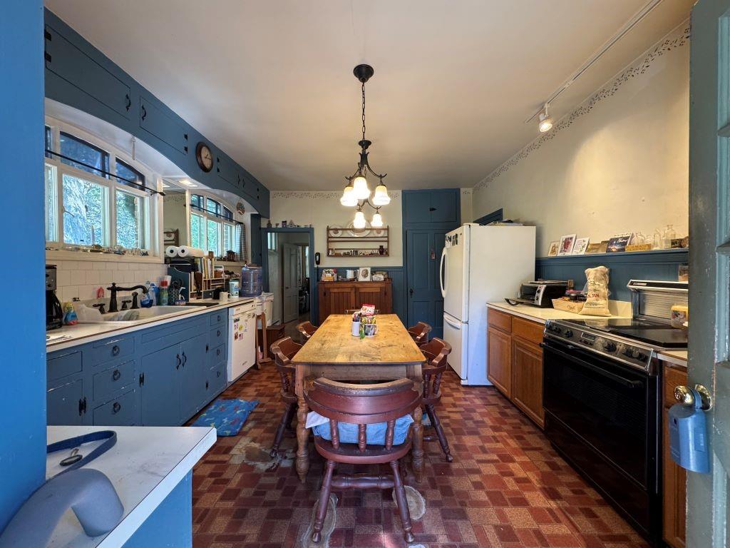 828 Brownhome Road New Castle, PA 16101 - Photo 14 of 47 a kitchen with stainless steel appliances granite countertop a stove a sink dishwasher a refrigerator and a dining table with wooden floor