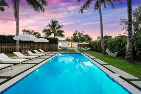 a view of swimming pool with lounge chair and dinning table under an umbrella