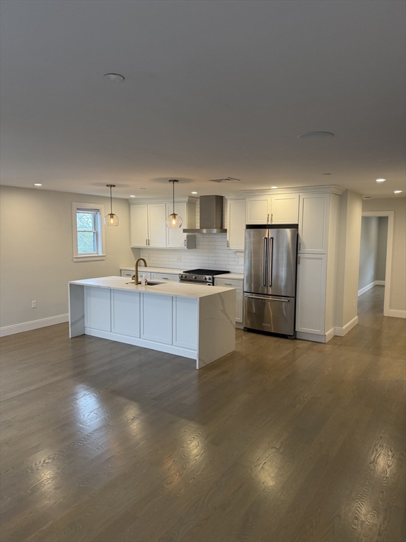 a kitchen with granite countertop a refrigerator and a stove top oven