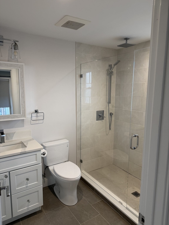 7 Saco Street, Unit 5 Boston, MA 02122 - Photo 11 of 13 a bathroom with a granite countertop toilet a sink a mirror and shower