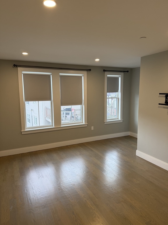 7 Saco Street, Unit 5 Boston, MA 02122 - Photo 9 of 13 a view of an empty room with wooden floor and a window