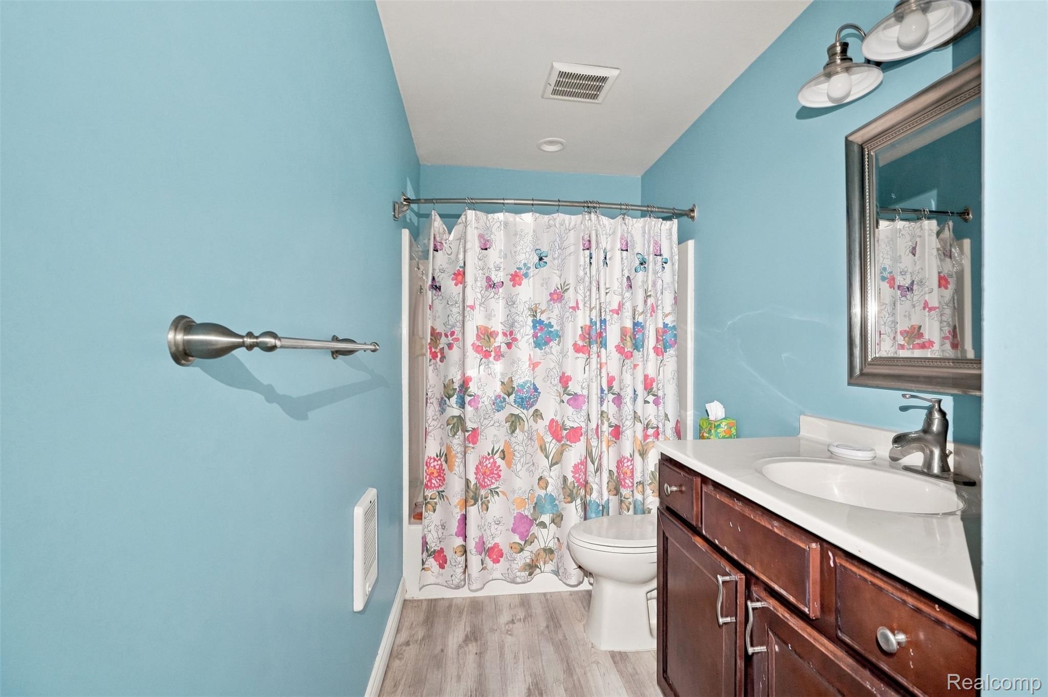 5161 Parker Road Fort Gratiot, MI 48059 - Photo 39 of 64 Bathroom featuring a single vanity with a white countertop, wood-finish cabinetry, and a framed mirror