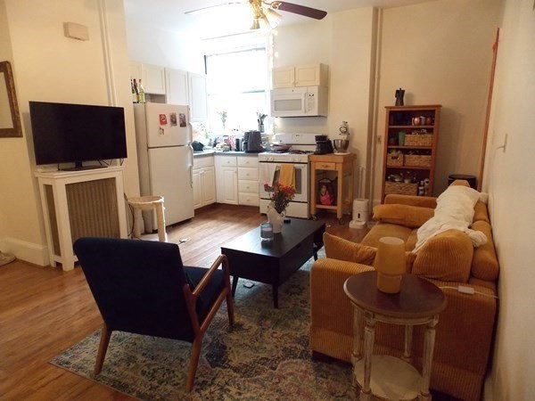514 Harvard Street, Unit 2D Brookline, MA 02446 - Photo 2 of 11 a living room with furniture a flat screen tv and a table