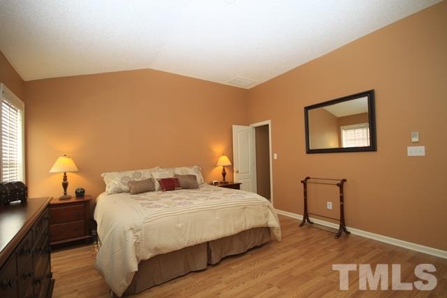 1439 Basinger Court Raleigh, NC 27612 - Photo 15 of 25 a bedroom with a bed and a lamp with window