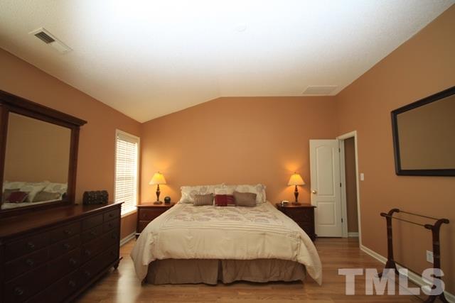 1439 Basinger Court Raleigh, NC 27612 - Photo 16 of 25 a bedroom with a bed and wooden floor