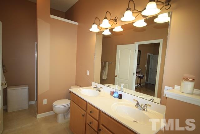 1439 Basinger Court Raleigh, NC 27612 - Photo 18 of 25 a bathroom with a toilet sink and mirror