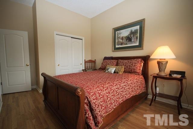 1439 Basinger Court Raleigh, NC 27612 - Photo 20 of 25 a bedroom with a bed and a lamp on table