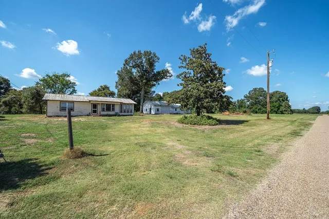 a view of a house with backyard and a tree