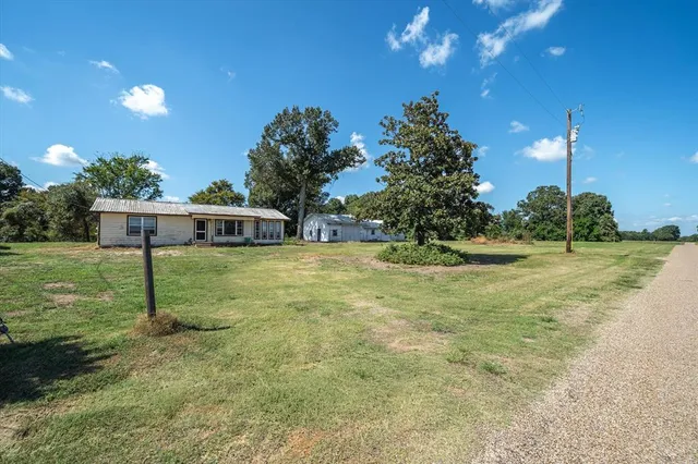 a view of a house with backyard and a tree