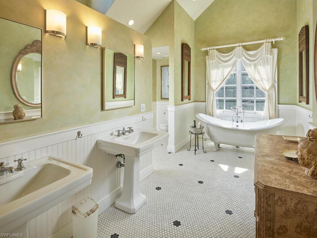 2750 Treasure Lane Naples, FL 34102 - Photo 15 of 28 a bathroom with a sink mirror and a bathtub