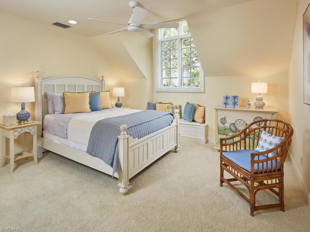 2750 Treasure Lane Naples, FL 34102 - Photo 20 of 28 a spacious bedroom with a bed and a chandelier
