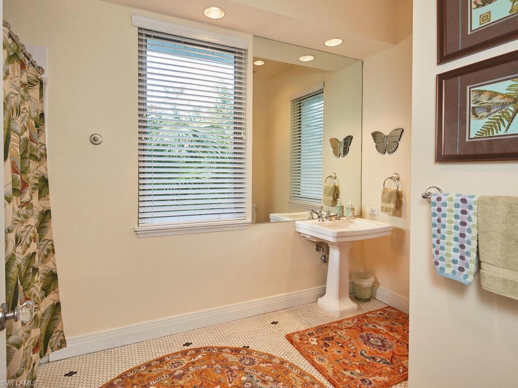 2750 Treasure Lane Naples, FL 34102 - Photo 23 of 28 a bathroom with a sink toilet a mirror and shower