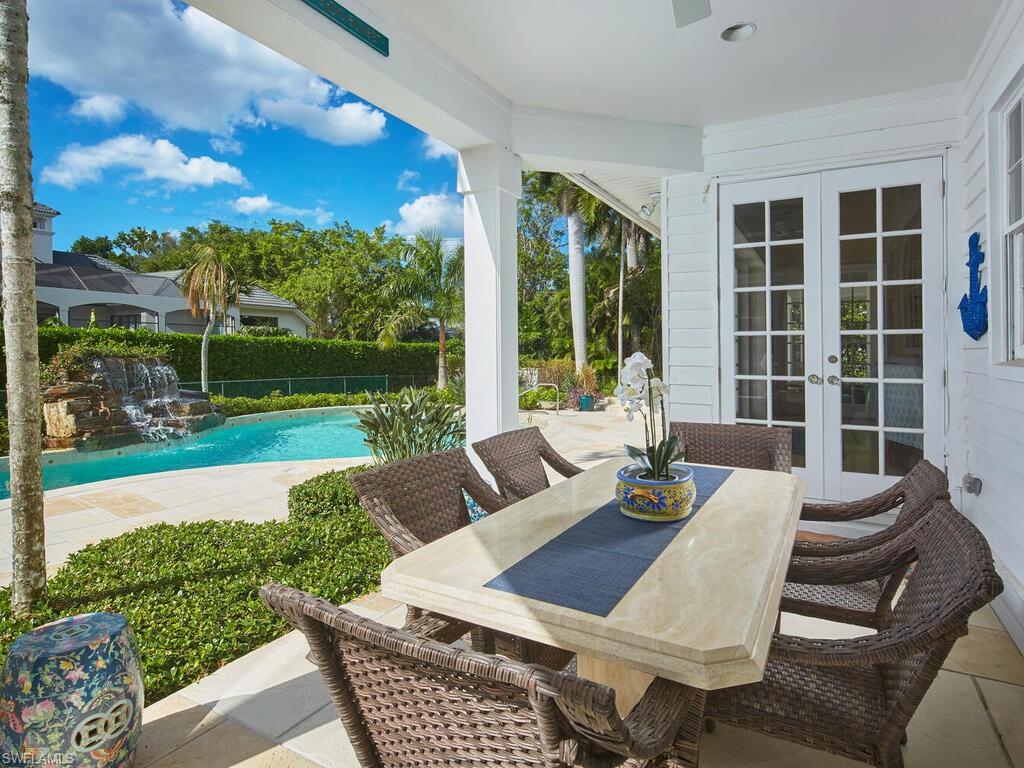 2750 Treasure Lane Naples, FL 34102 - Photo 25 of 28 a view of a patio with couches chairs dining table and chairs