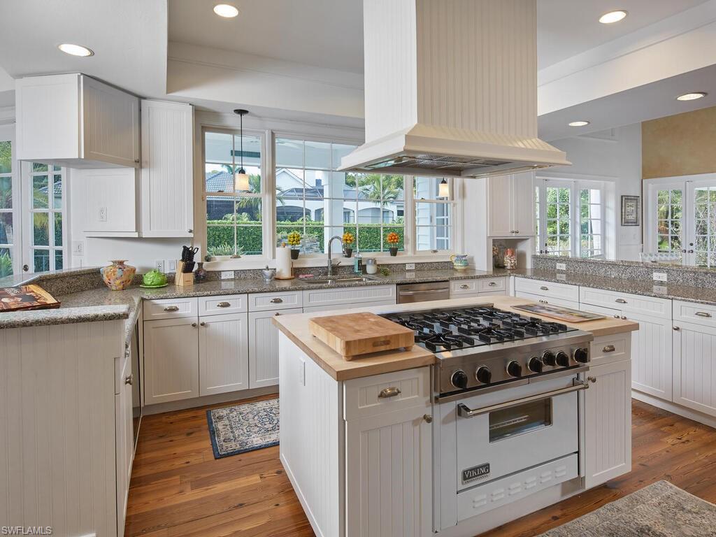 2750 Treasure Lane Naples, FL 34102 - Photo 10 of 28 a kitchen with stainless steel appliances granite countertop a stove a sink and a microwave