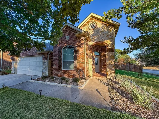 a front view of a house with a yard and potted plants