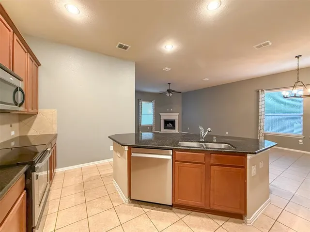 a kitchen with stainless steel appliances granite countertop a sink stove and cabinets