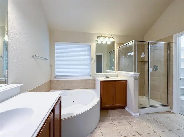 a spacious bathroom with a bathtub sink and mirror