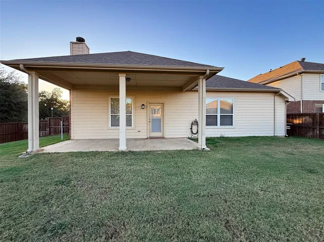 a view of a yard with a wooden fence