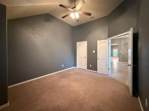 a view of a room with a ceiling fan and a window